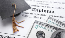 Image of graduation cap and stack of money on top of a diploma.